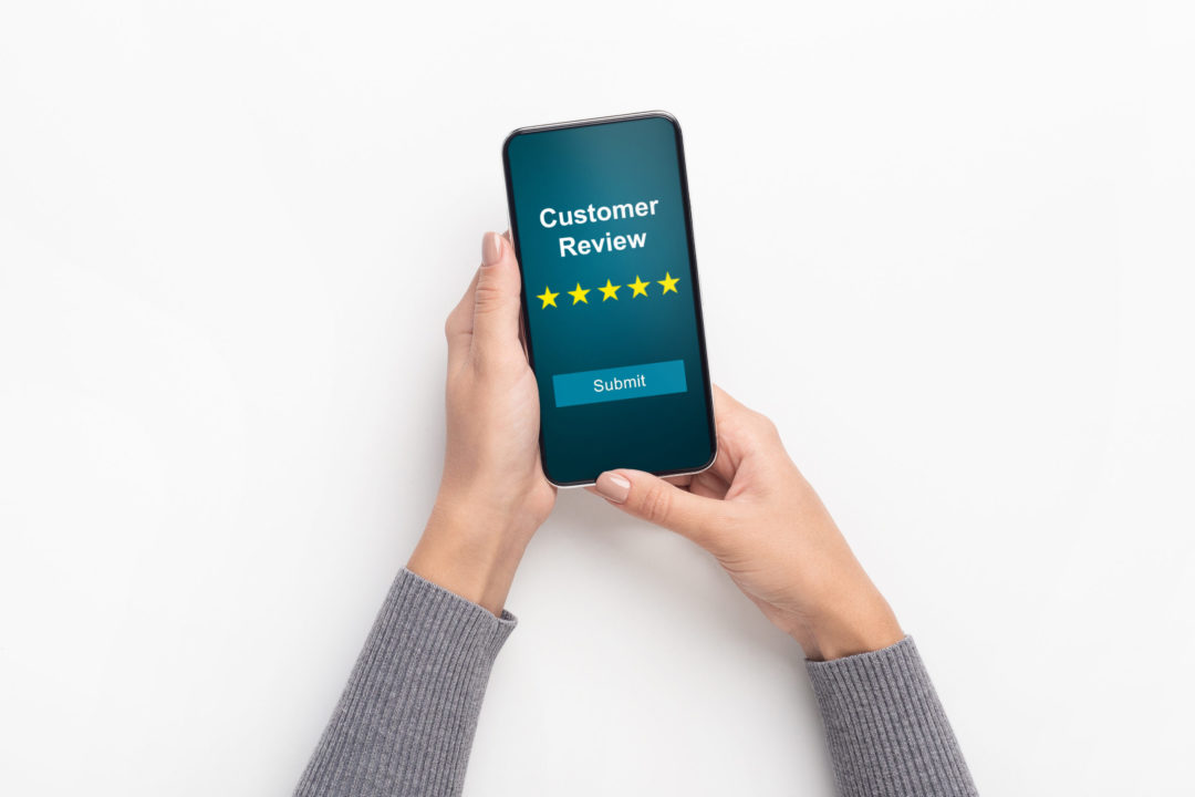 Business woman holding cell phone with customer review text